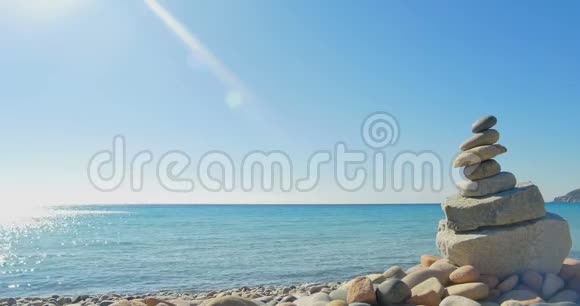 波浪降落在石滩上冥想石头金字塔清澈的蓝色海水视频的预览图