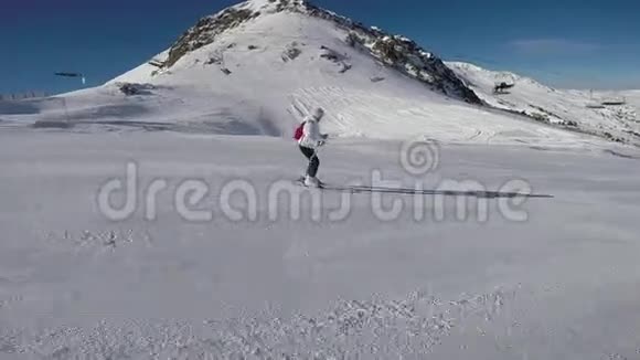 一个女人在滑雪道上滑雪阳光和雪山视频的预览图