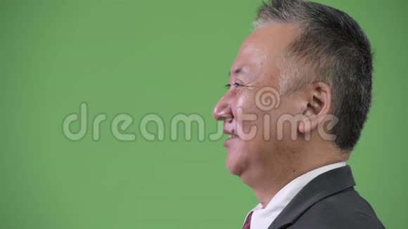 成熟的日本商人在绿色背景下微笑的轮廓视频的预览图