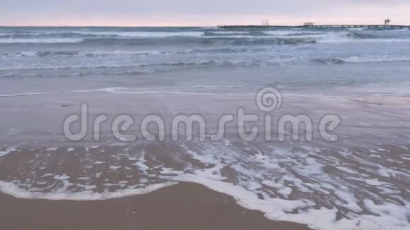 大海里波涛汹涌美丽的海景与码头沙滩在日落视频的预览图