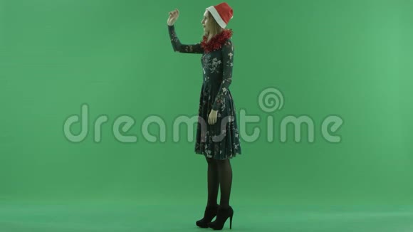 使用增强现实触摸屏技术制作圣诞帽的年轻美女视频的预览图