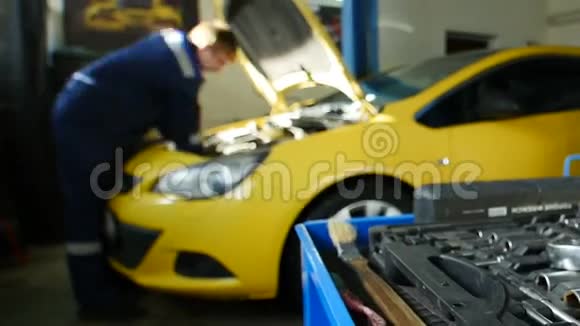 机修工在专业汽车服务部附近修理黄色汽车延时视频的预览图