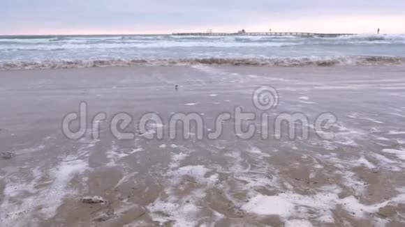 大海里波涛汹涌美丽的海景与码头沙滩在日落视频的预览图
