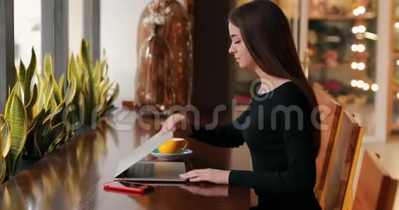 坐在咖啡馆里用笔记本电脑工作的女人视频的预览图