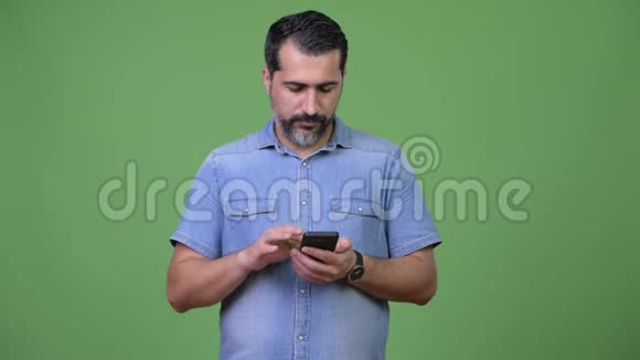 一个英俊的波斯胡子男人用电话和得到坏消息视频的预览图