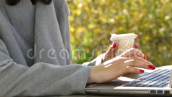 大自然中的一个女孩坐着一台笔记本电脑喝咖啡视频的预览图