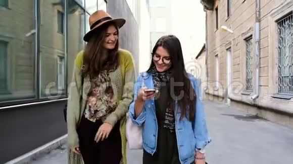 两个漂亮的女朋友穿过城市的街道笑着视频的预览图
