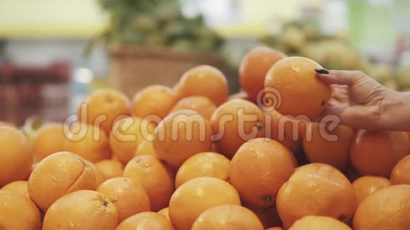年轻漂亮的女人在超市为家人购买新鲜健康的橘子和水果手臂选择美味视频的预览图