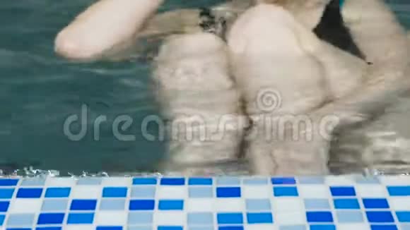 无法辨认的女人在游泳池里游泳视频的预览图
