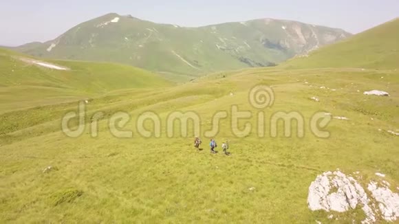 游客在绿山谷空景下徒步游览夏季草地视频的预览图