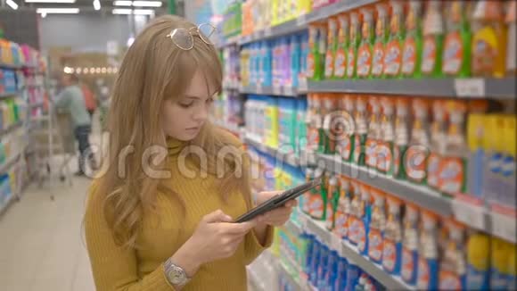 女人在超市购物在平板电脑上使用移动应用程序视频的预览图