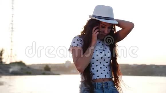 年轻女子打电话走在沙滩上视频的预览图
