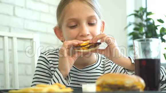 小孩吃快餐小孩在餐馆吃汉堡包小孩喝果汁视频的预览图