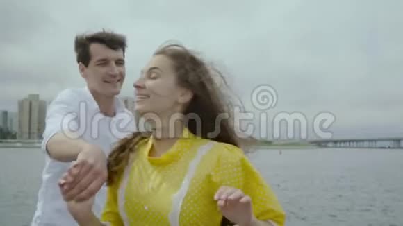 快乐迷人的女人和男朋友在城市的堤岸跳舞视频的预览图