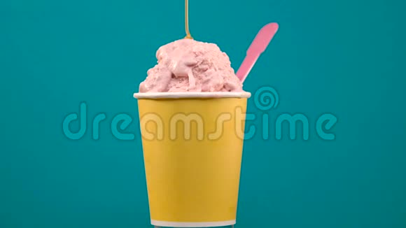 用塑料勺在黄色纸杯里旋转焦糖酱草莓冰淇淋视频的预览图