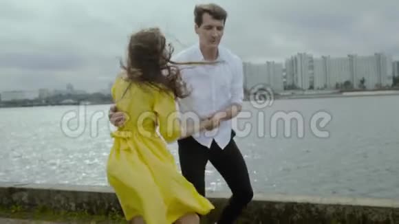 雨天微笑的男女青年在码头上跳着滑稽的舞蹈视频的预览图