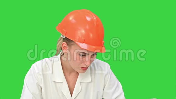 女工程师在紧张的头盔检查施工图上一个绿色的屏幕色度键视频的预览图