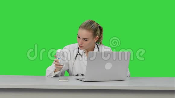 一位护士用笔记本电脑在绿色屏幕上研究新药丸的肖像Chroma键视频的预览图