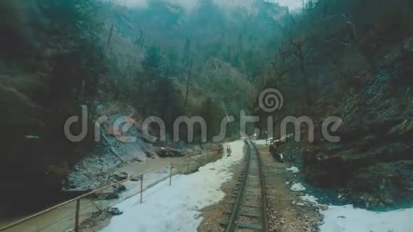 一列旧火车或火车头正沿着狭窄峡谷中的窄轨铁路行驶火车沿着火车行驶视频的预览图