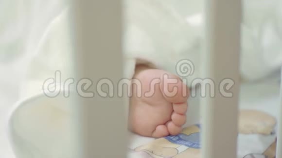 婴儿床上睡着的婴儿的腿视频的预览图