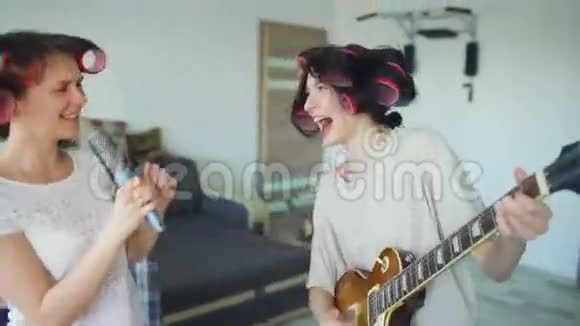 两个有趣的女孩用梳子唱歌弹电吉他跳舞在家唱歌玩得开心视频的预览图
