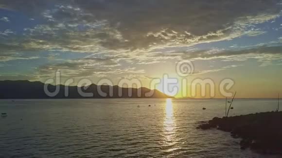 沿着海岸剪影向梦幻般的日出行进视频的预览图
