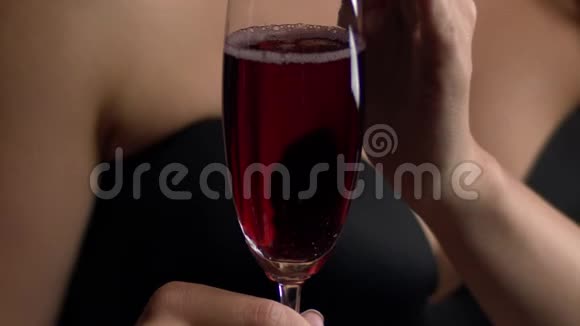 女人碰一杯酒红色的起泡葡萄酒装满了一杯女人喝一杯红酒视频的预览图