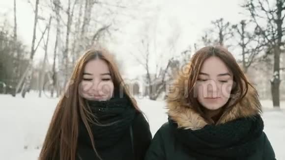 两个女人走过冬日的小巷背景是雪树视频的预览图