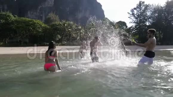 人们泼水在人身上欢乐的年轻游客群体在山区的海滩上享受乐趣视频的预览图
