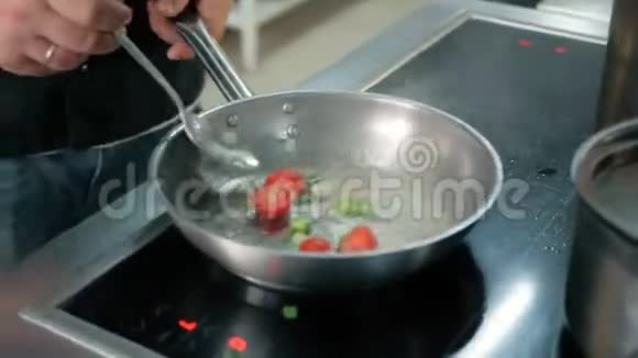 厨师把西红柿放进锅里放在餐厅的厨房里视频的预览图