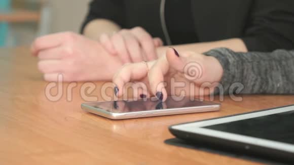 女人把手指按在智能手机屏幕上视频的预览图