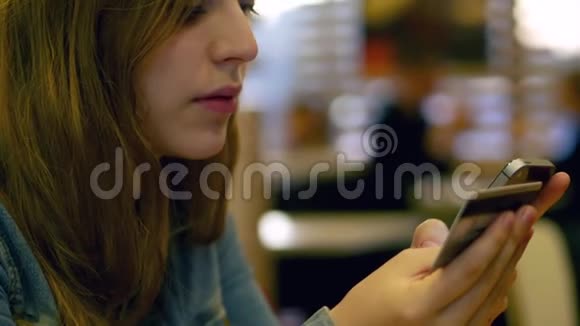 少女在咖啡馆用智能手机支付信用卡4K视频的预览图