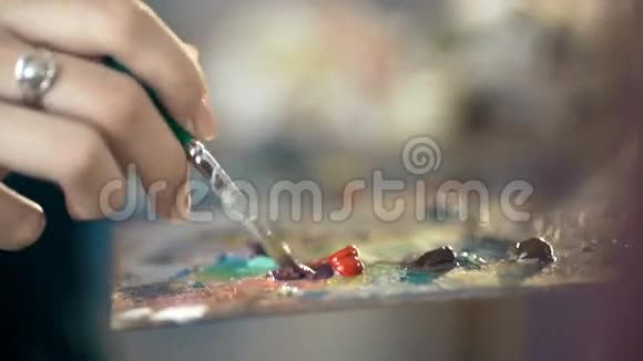 艺术家手持画笔和色彩斑斓的调色板视频的预览图