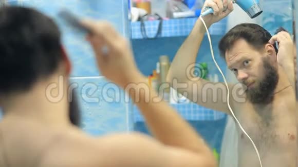 欧洲人在镜子前的浴室里吹干头发和胡须视频的预览图