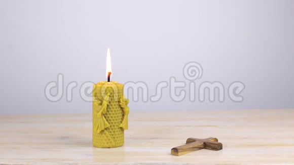 木桌上有正统十字架的蜡烛视频的预览图