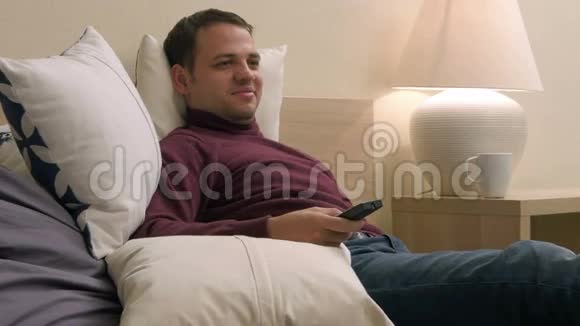 成熟的帅哥在他的酒店房间里放松寻找电视上看的东西视频的预览图