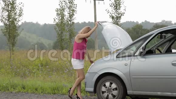 女人打开破车的引擎盖一个穿短裙的女孩靠在一台损坏的发动机上视频的预览图