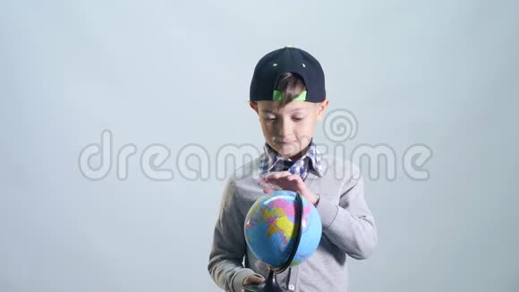男孩用手指转动地球选择国家视频的预览图