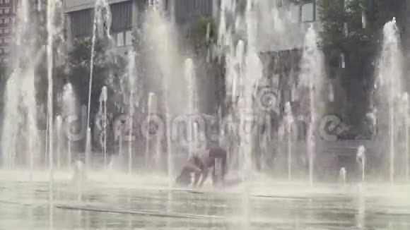年轻女子站在喷泉里的头上视频的预览图