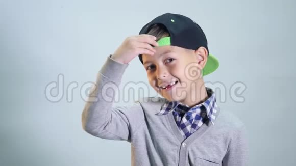 戴帽子的孩子伸直前锁露出舌头伸出舌头在灰色的背景下分开视频的预览图