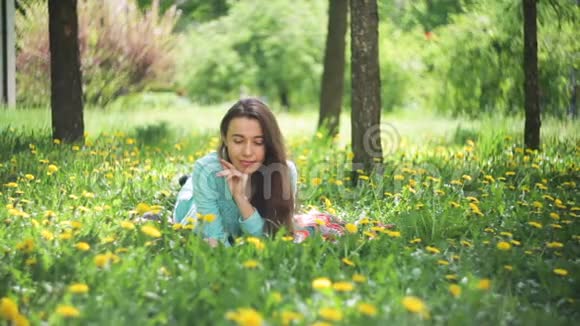 草甸的美女美丽的少女户外享受大自然吧健康的微笑女孩躺在草地上视频的预览图