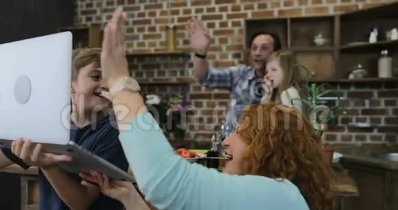 家庭制作视频电话使用笔记本电脑在厨房烹饪食物快乐的父母和孩子双手视频的预览图
