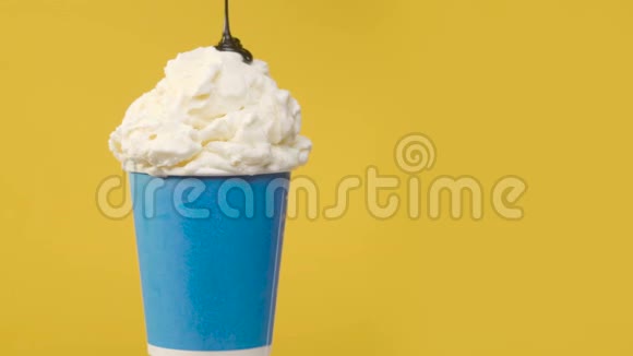 在蓝纸杯中用巧克力酱旋转软香草冰淇淋视频的预览图