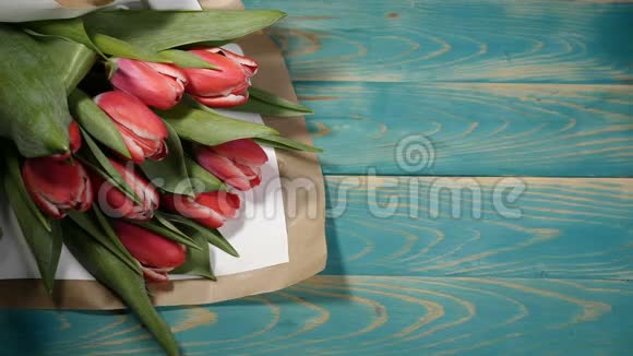 在木桌上可以看到一张爱情短信和郁金香花束恋爱关系的概念圣视频的预览图