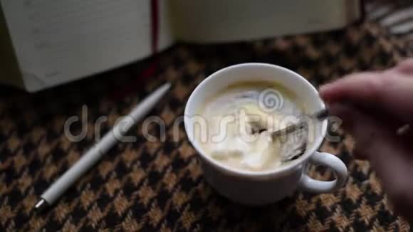 早晨咖啡在笼子里的棕色格子布背景下倒入杯中视频的预览图