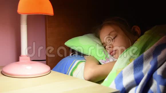 男人的手从婴儿床上的台灯里拿出了灯睡着了的女孩视频的预览图