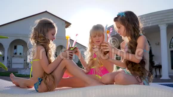 可爱的孩子们在暑假的名人小女孩手里拿着鸡尾酒在别墅休息昂贵视频的预览图