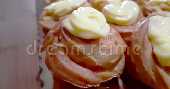 女人准备美味的奶油甜点名为圣约瑟夫的zeppole用勺子在上面插入带有糖浆的黑樱桃视频的预览图