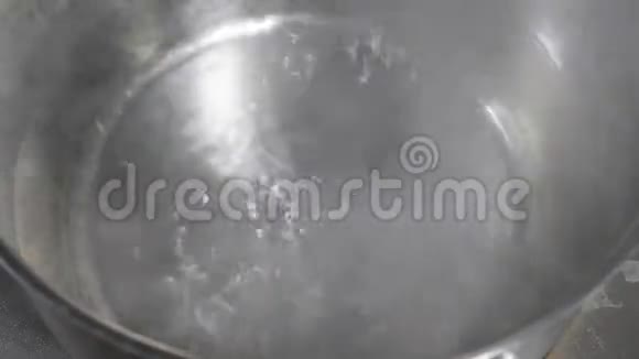 再培训厨房的电炉上锅里烧水在不锈钢锅里视频的预览图