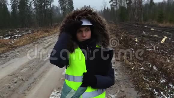 在潮湿的冬日里女林业雇员散步和讲述视频的预览图